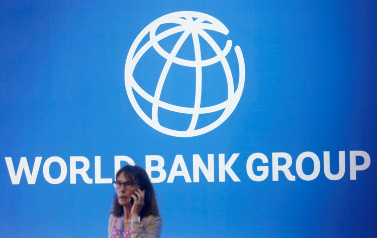 FILE PHOTO: A participant stands near a logo of World Bank at the International Monetary Fund - World Bank Annual Meeting 2018 in Nusa Dua, Bali, Indonesia, October 12, 2018. REUTERS/Johannes P. Christo/File Photo
